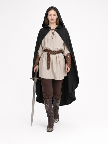 Black hooded cloak shown on an adult model walking over a medieval-style outfit while holding a sword
