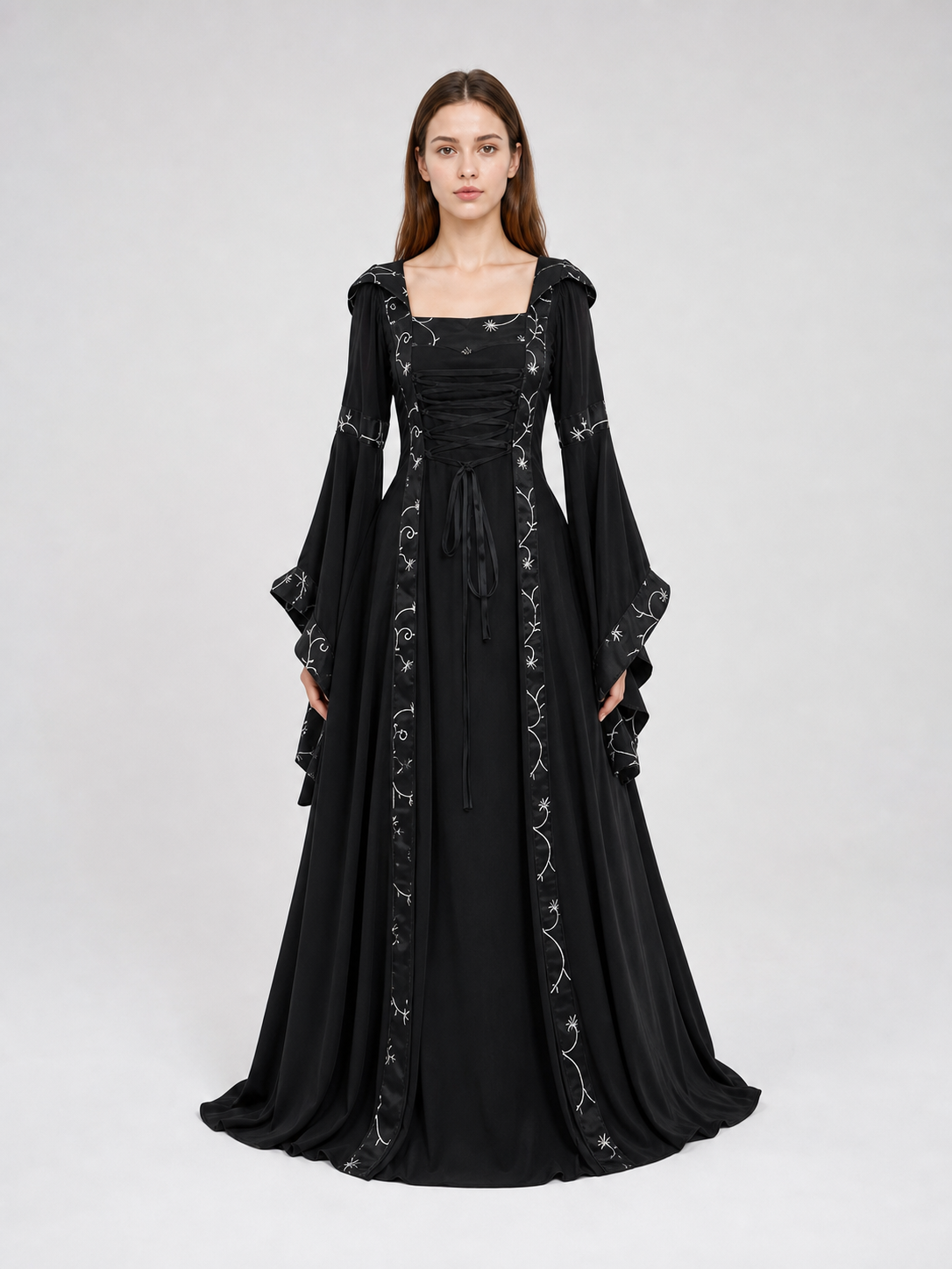 The dress is designed in a gothic style with elements of Victorian aesthetics. The model features a flared silhouette, a square neckline, and long sleeves with flared cuffs. The bodice is decorated with gathers that emphasize the garment’s 