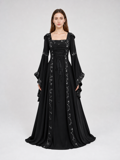 The dress is designed in a gothic style with elements of Victorian aesthetics. The model features a flared silhouette, a square neckline, and long sleeves with flared cuffs. The bodice is decorated with gathers that emphasize the garment’s 