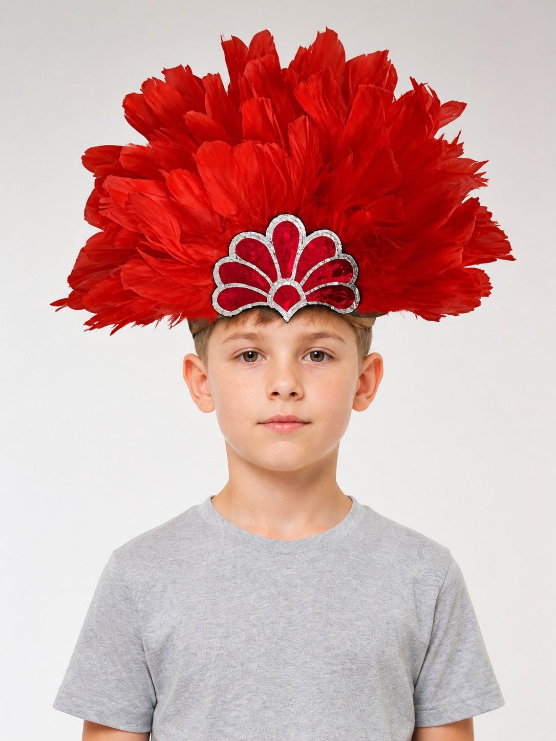 Red feather headpiece with a silver-trimmed fan decoration, worn by a child in a front-facing portrait
