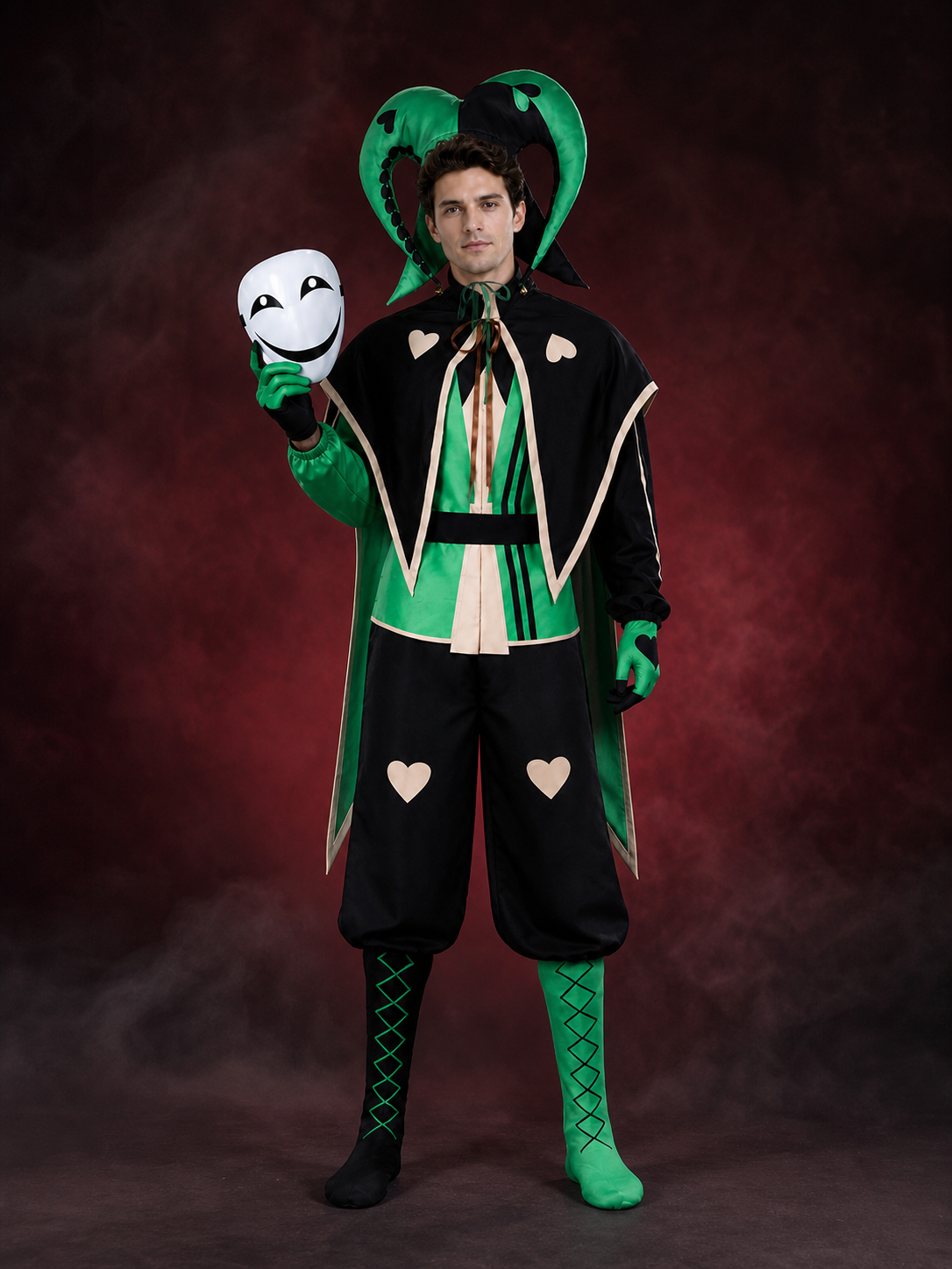 Black and green jester clown costume worn with the white smiling mask held in hand