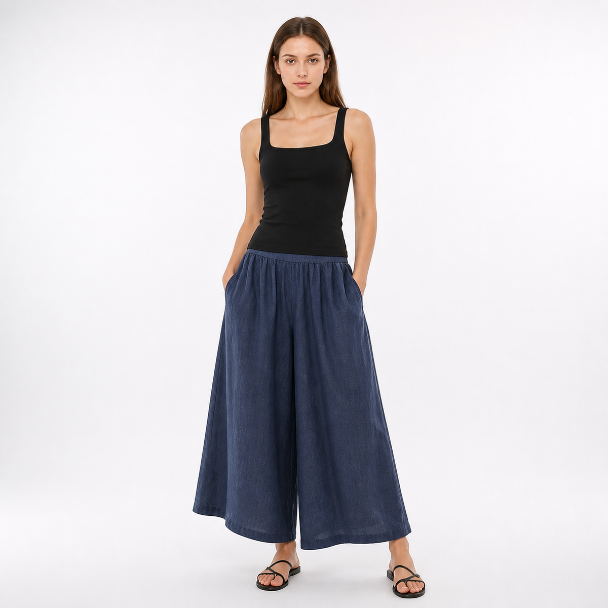 Dark blue wide leg pants with side pockets shown on a model wearing a black tank top and sandals