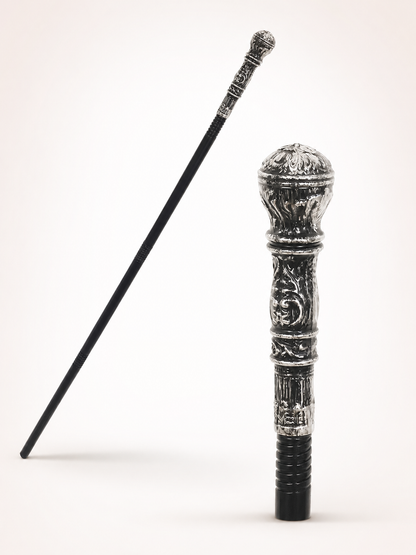 Black cane shown full length beside a close-up of its silver round head and embossed ornamental handle on white