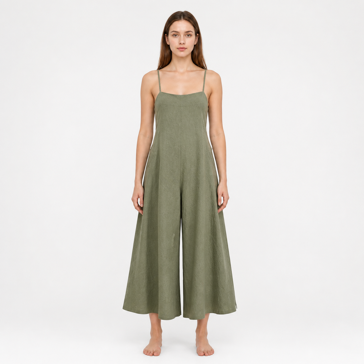 Olive green wide-leg jumpsuit with a straight neckline and thin straps, shown full-body on a barefoot model against a white background