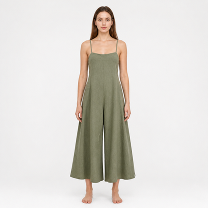 Olive green wide-leg jumpsuit with a straight neckline and thin straps, shown full-body on a barefoot model against a white background