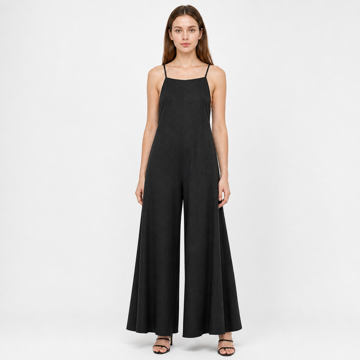 Black wide-leg jumpsuit with a straight neckline and thin straps, shown full-body on a model in a light studio