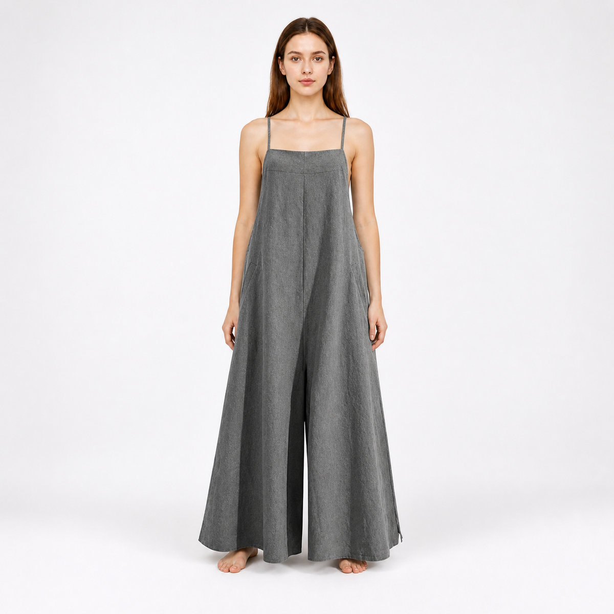 Gray wide-leg jumpsuit with thin straps and a center front pleat, shown full-length against a plain white background