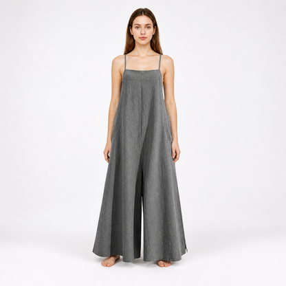 Gray wide-leg jumpsuit with thin straps and a center front pleat, shown full-length against a plain white background