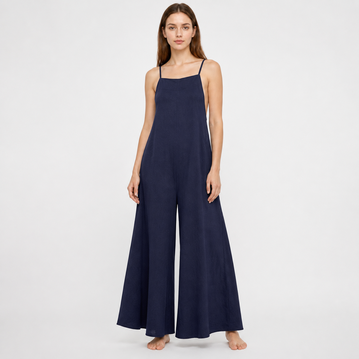 Navy blue wide-leg jumpsuit with a straight neckline and thin straps shown full-length on a model against a white background