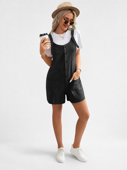 Black bib shorts with tied shoulder straps and front pockets, styled on a model wearing a white T-shirt and hat