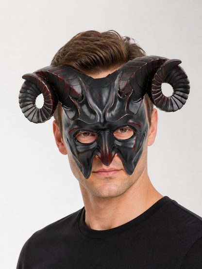 Man wearing a glossy black horned mask with curled ridged horns and pointed facial details in a close-up portrait