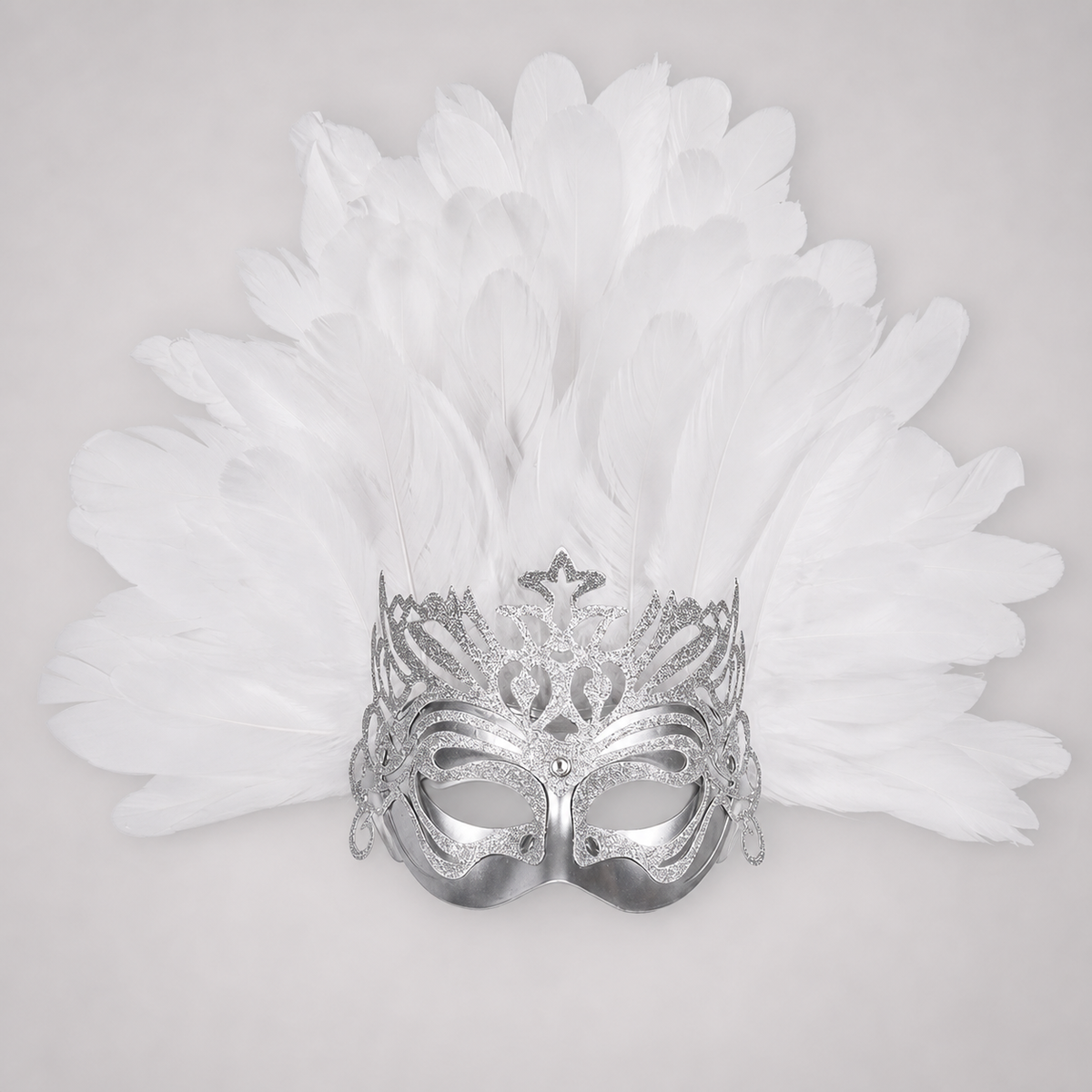 Close-up of a silver eye mask with glittering cutout patterns, side loops, and layered white feathers