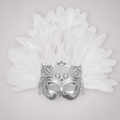 Close-up of a silver eye mask with glittering cutout patterns, side loops, and layered white feathers