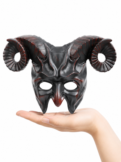 Glossy black horned mask with curled ridged horns resting above an open hand against a white background