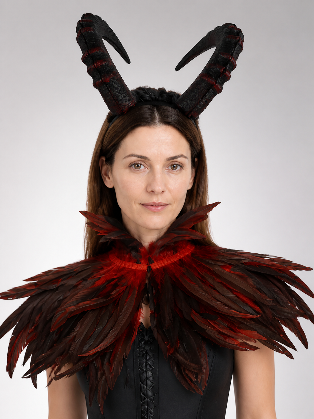 Horned headpiece with black and red textured horns, shown in a close front portrait with a dark feathered collar