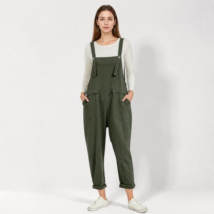 Full-body front view of dark green textured bib overalls with a chest pocket, adjustable shoulder straps, side pockets, and rolled cuffs