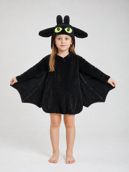 Black plush bat costume shown full-body on a child, with hood, upright ears, large eyes, and extended side wings