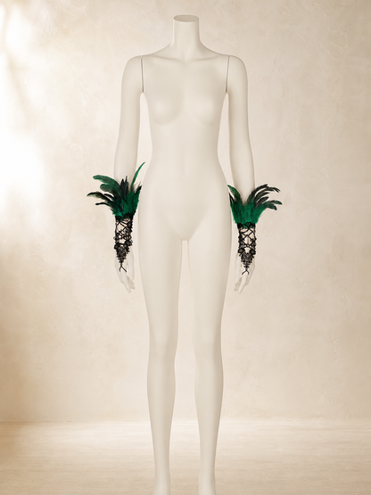 Black lace mesh fingerless gloves with green and black feathers, shown on a mannequin in a styled setting