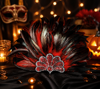 Red and black feathered headpiece with a jeweled red centerpiece displayed on black fabric in a candlelit setting