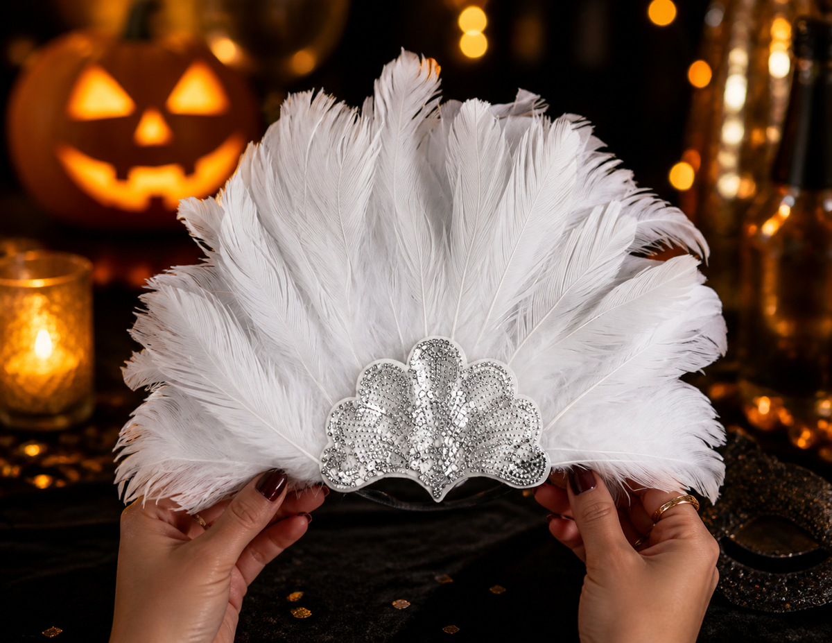 White feather headband held in both hands in a dim festive setting, with a silver sequined front and decorative lights