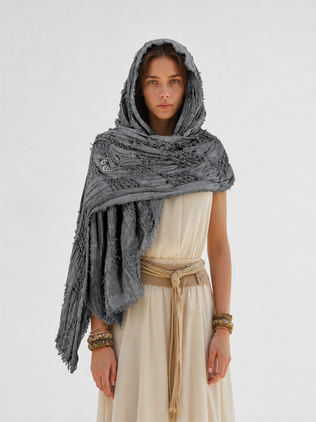 This large scarf-wrap is designed as a rectangular drape with a striking textured surface. The black-and-gray color palette is accented with lighter gray tones, giving the piece a distinctive look that pairs easily with different outfits. T