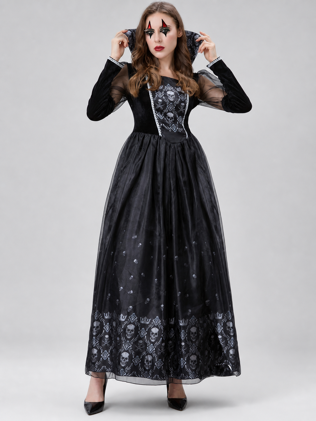 Black gothic-style dress with silver-white decorative skull motifs. The design features a long silhouette with sheer mesh sleeves and an accent neckline with a pointed shape. Silver decorative trim is placed across the chest, complementing 