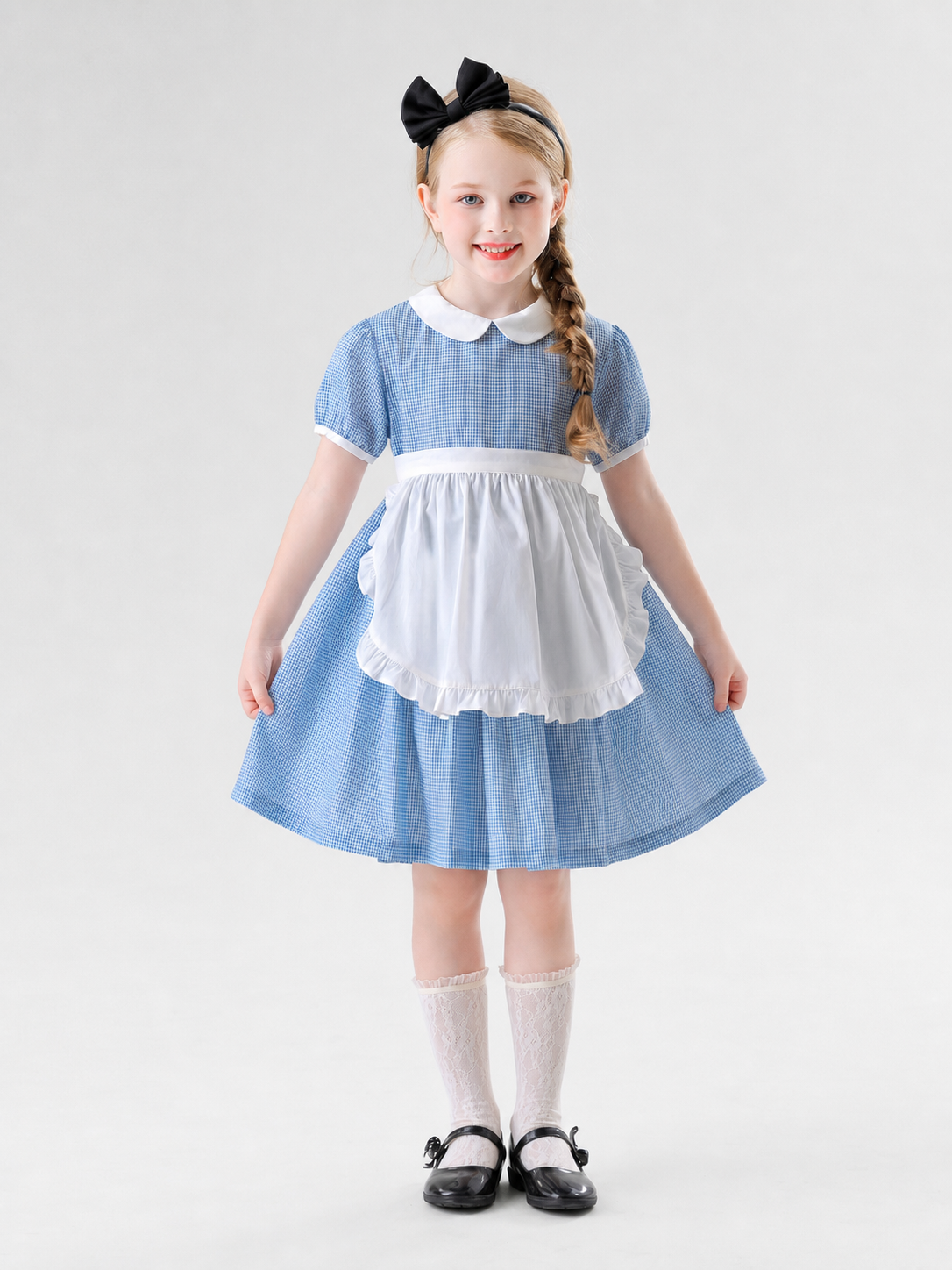 The dress is designed in a retro style, combining a blue-and-white small check pattern with distinctive white details. A white apron-like insert is featured on the front, while the white Peter Pan collar and white waist detail reinforce the