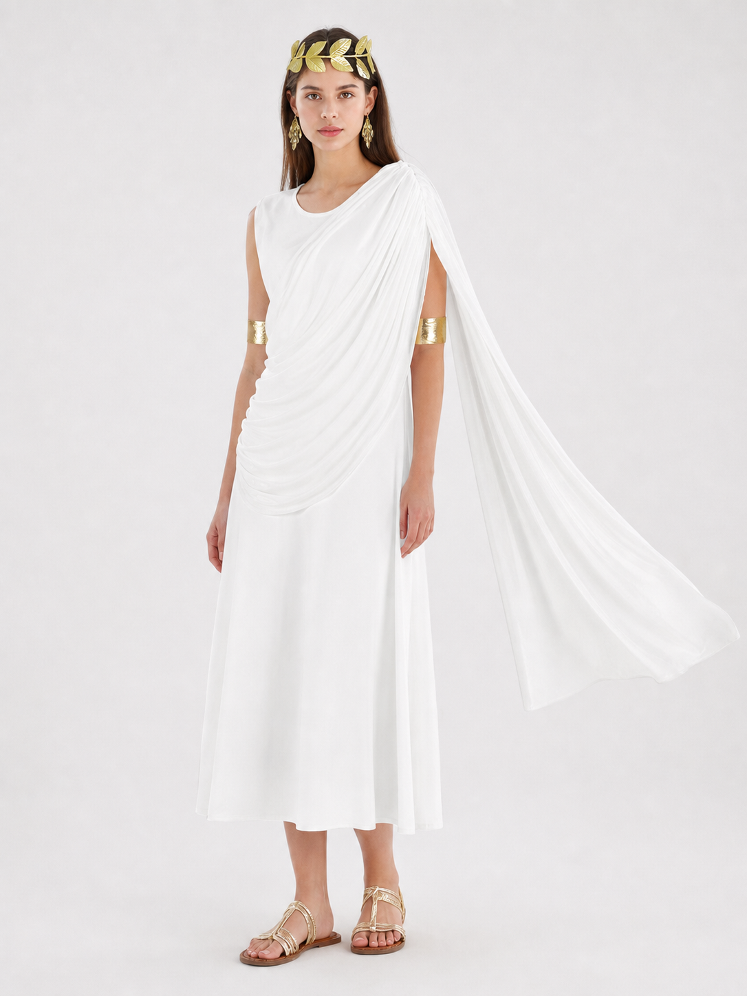 Full-body model wearing a white draped dress with a flowing shoulder train and gold accessories in a decorated interior