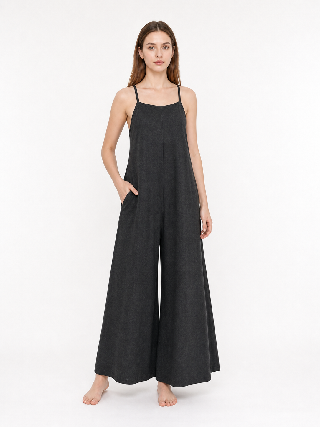 Black wide-leg jumpsuit with thin straps and a straight neckline, shown full-body on a model against a plain background