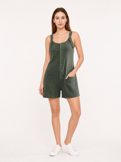 Olive green textured overall shorts worn with a white T-shirt and sneakers, shown full-body with tied straps, front buttons and side pockets