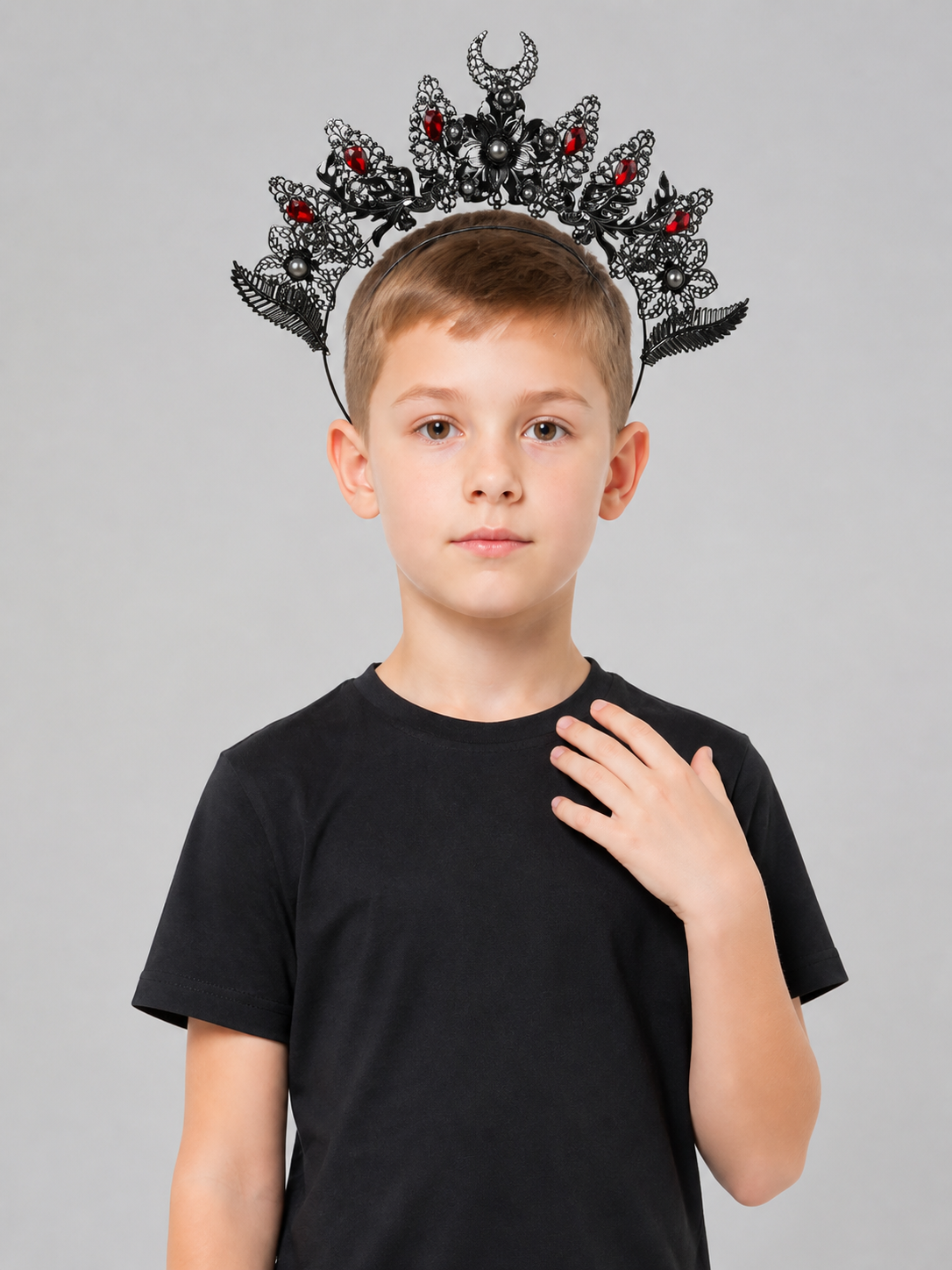 Ornate black and silver-look horned headpiece with red stones and pearl-like beads, shown from the front on a child in a black shirt