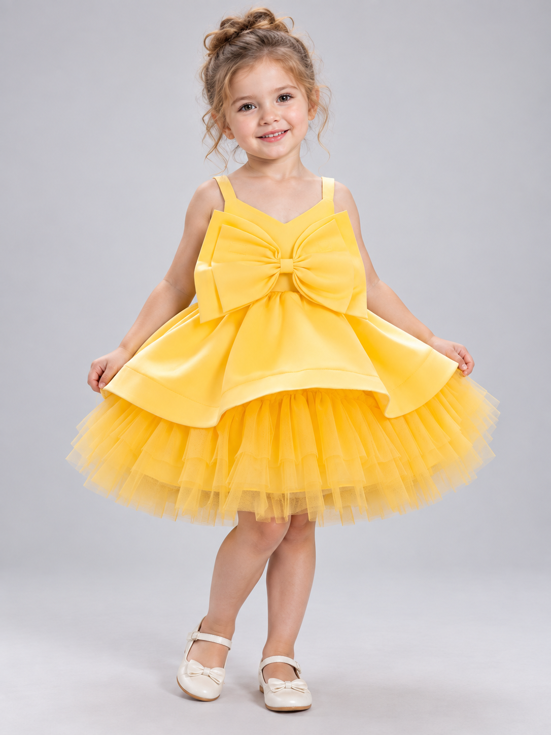 Yellow dress with a bow and a multi-layer tulle skirt