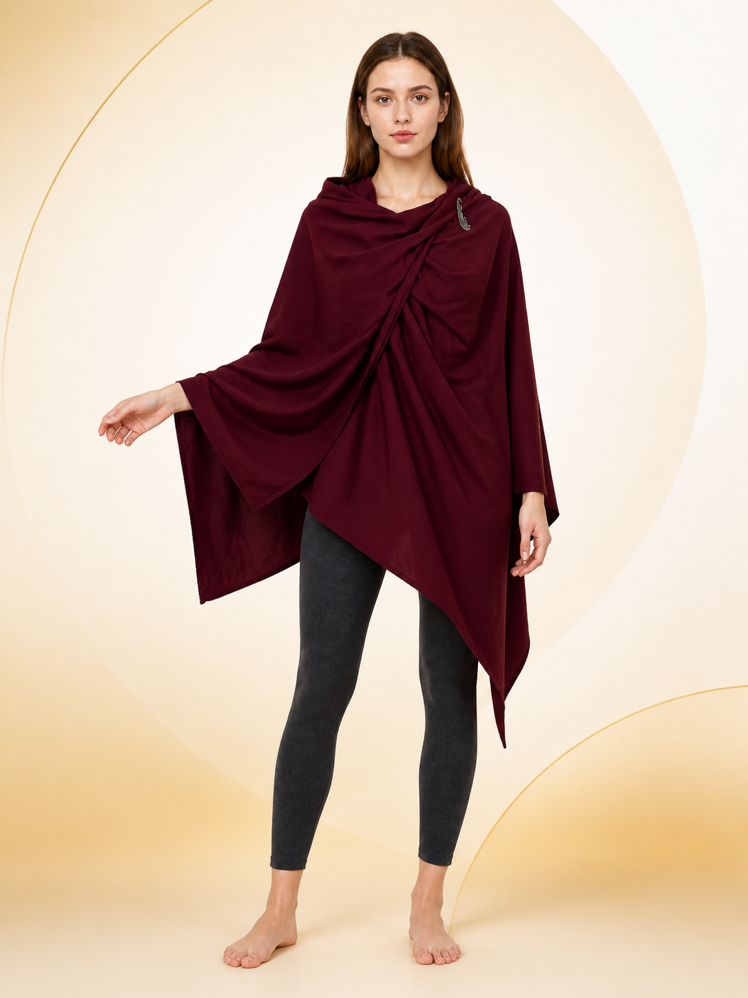 Burgundy cloak with draped front and shoulder fastener, modeled by a woman against a cream decorative backdrop