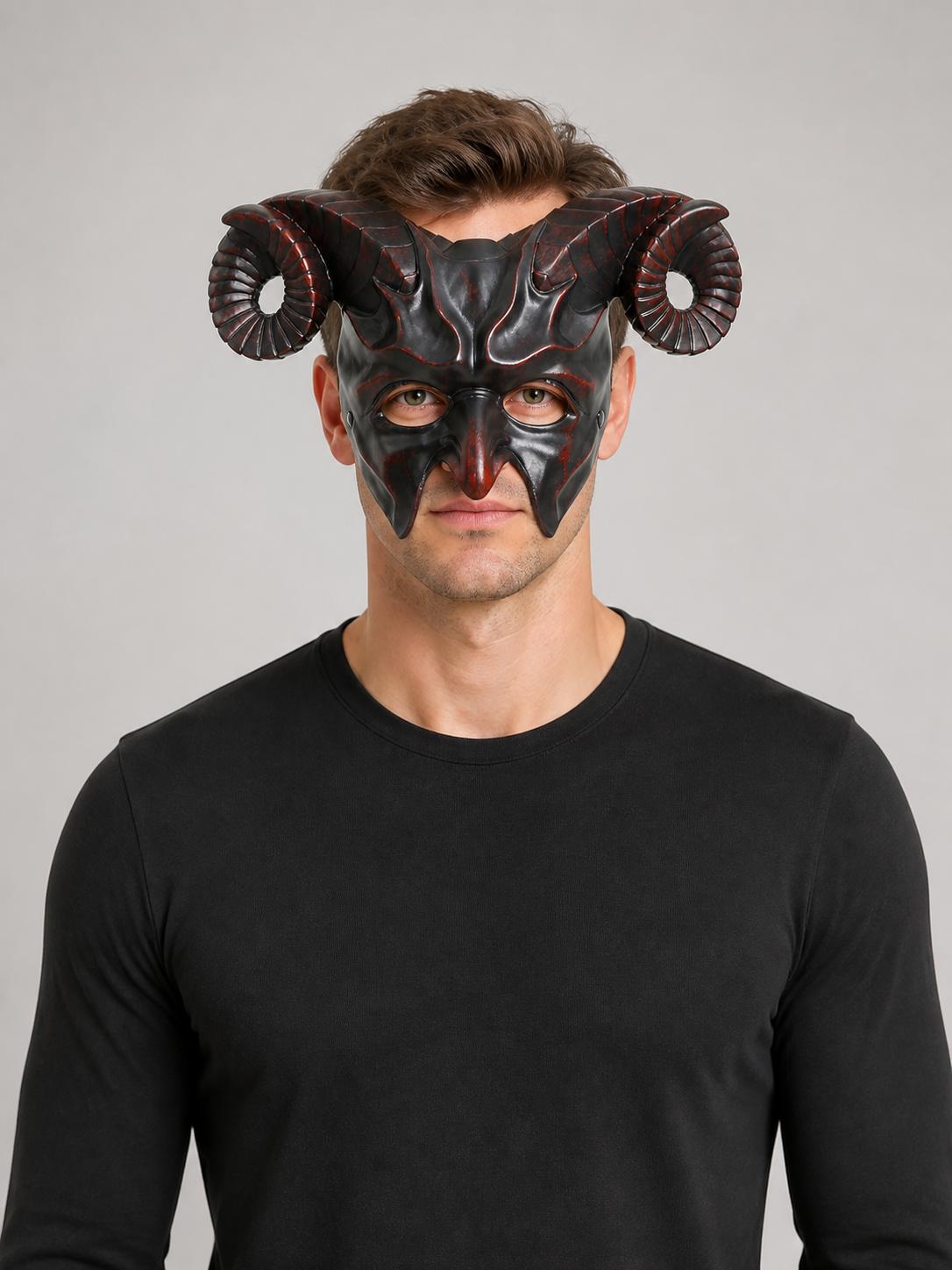 Man wearing a glossy black horned mask with curled ridged horns and pointed facial details over a black shirt