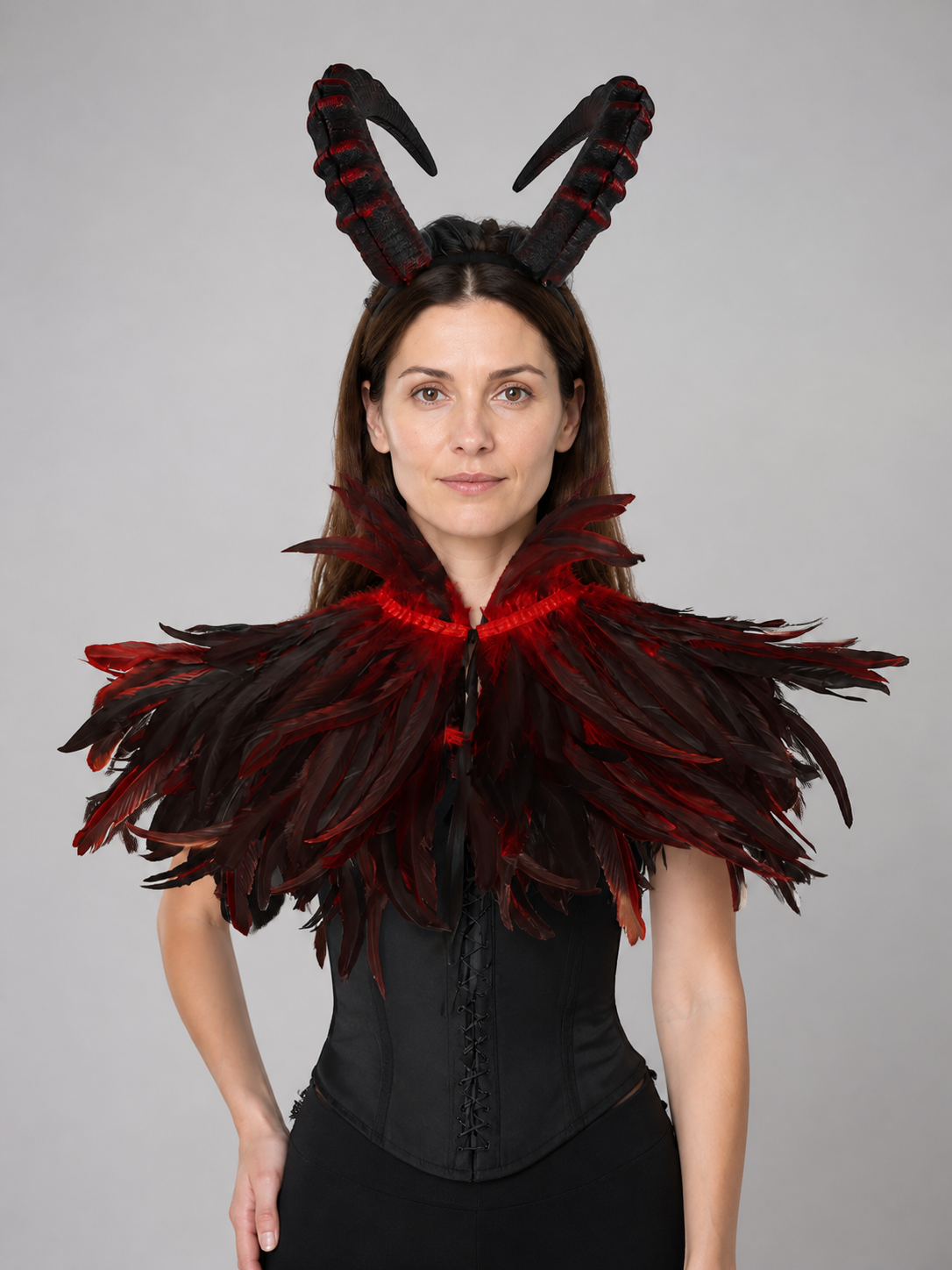 Black and red horned headpiece with a wide layered feather collar, shown on a model against a gray background