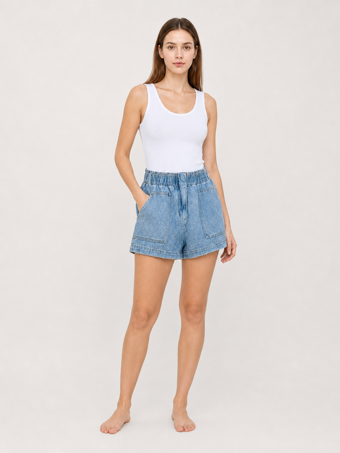 Light blue denim shorts shown full-body on a model against a plain background, with a high elastic waistband and loose fit