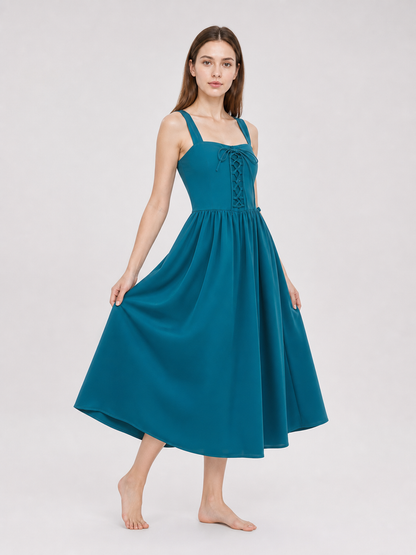 Teal strappy dress with front lacing and a wide gathered skirt held out on both sides by the model