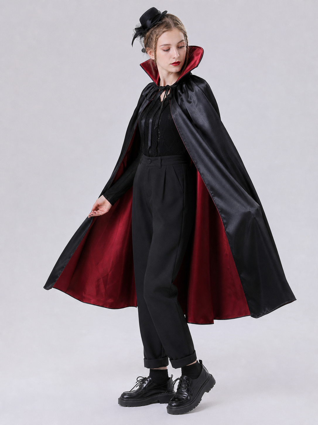 The long black cape is designed to create a vampire look for cosplay, Halloween, and stage performances. The cape is black and features a loose silhouette with long, draping panels and an opening lower edge. The upper section has a hooded o