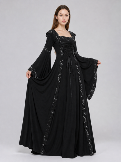 The dress is designed in a gothic style with elements of Victorian aesthetics. The model features a flared silhouette, a square neckline, and long sleeves with flared cuffs. The bodice is decorated with gathers that emphasize the garment’s 