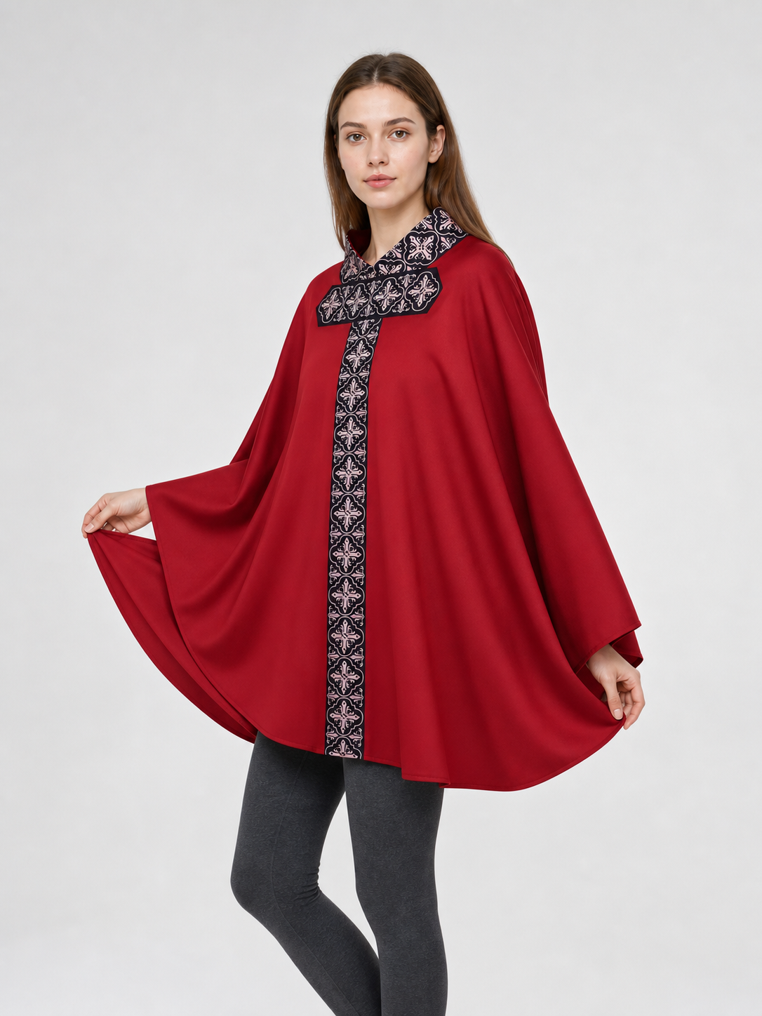 The cape is red with black decorative elements. It has a loose cloak-style silhouette, wide sleeves, and a collar with black patterned detailing. The front features a vertical decorative stripe down the center and a horizontal stripe across