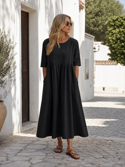 This black long dress features a round neckline, elbow-length sleeves, and a relaxed A-line silhouette. The solid-color design gives it a clean look and makes it easy to pair with different everyday wardrobe pieces. The top has a round neck