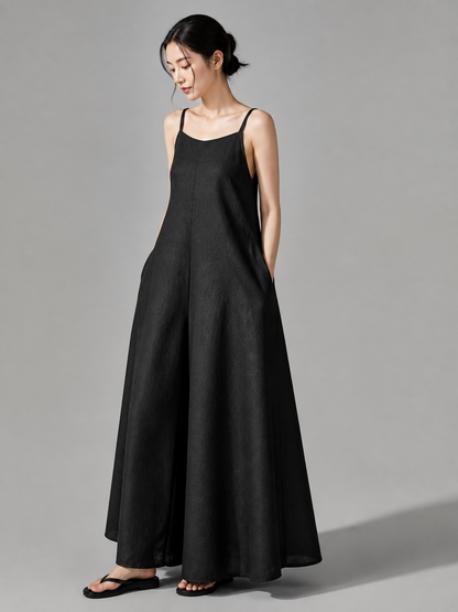 Loose black bib overalls with thin shoulder straps. The design features a simple solid black color and a straight, wide-leg silhouette with long pant legs. The upper portion is styled as a bib, while the thin shoulder straps complement the 
