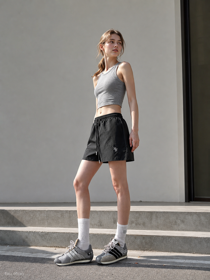 Loose-fit women's shorts with an elastic waistband and drawstring. The design features a minimalist style and a noticeable detail at the front—a drawstring for adjustment. The elastic waistband helps maintain a neat fit, while the loose cut