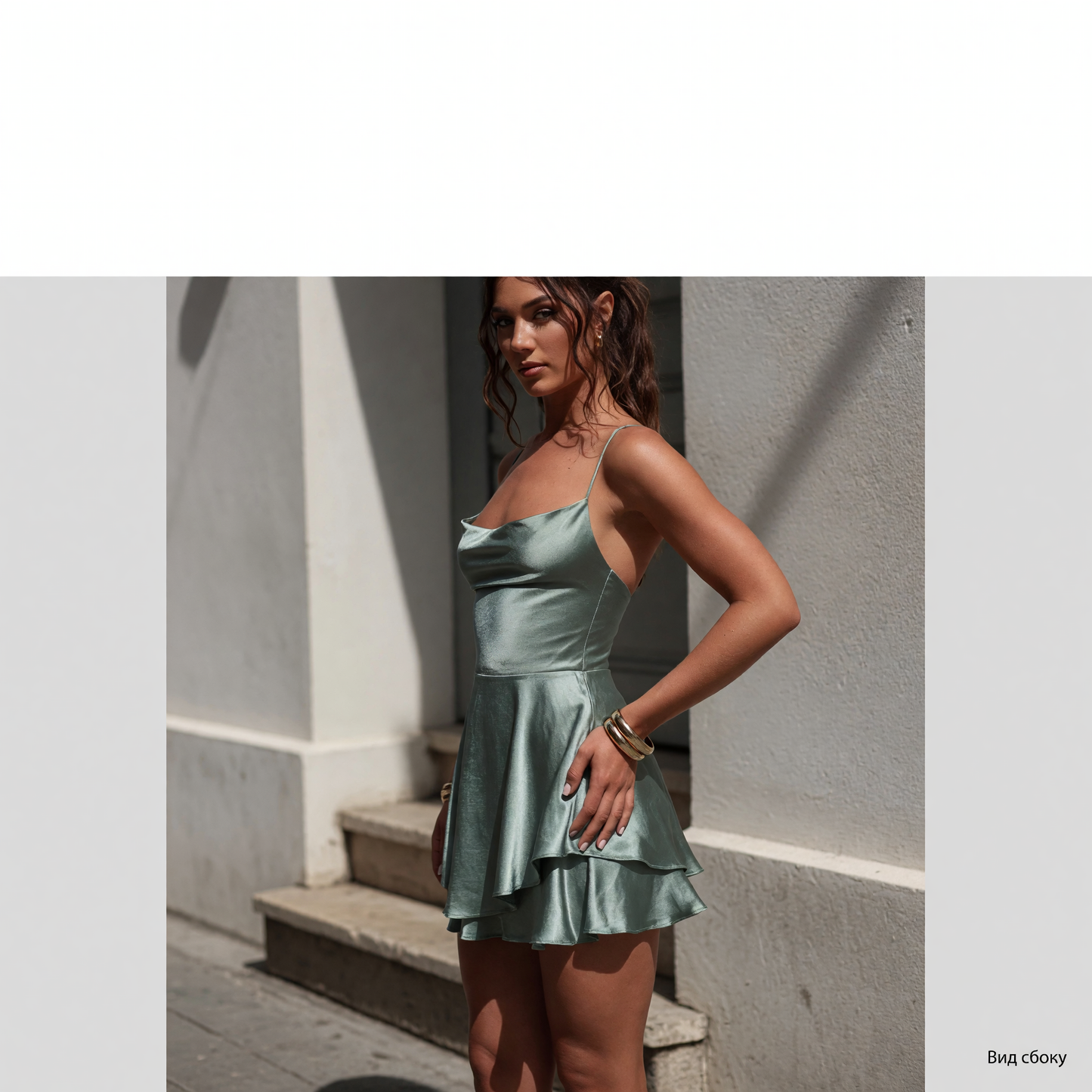 This short light green dress features thin straps and distinctive draping at the neckline. The design has a fitted bodice and a flared skirt that creates a lightweight silhouette with a gradual flare toward the hem. The draped neckline and 