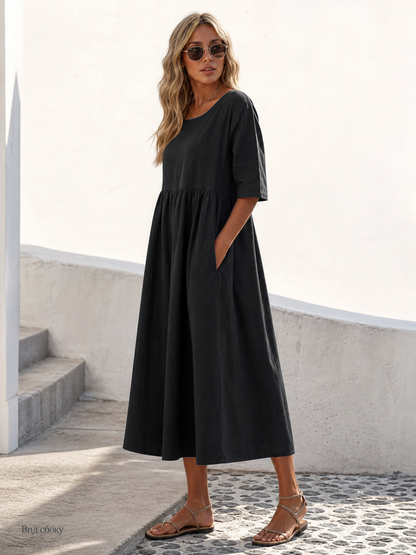 This black long dress features a round neckline, elbow-length sleeves, and a relaxed A-line silhouette. The solid-color design gives it a clean look and makes it easy to pair with different everyday wardrobe pieces. The top has a round neck
