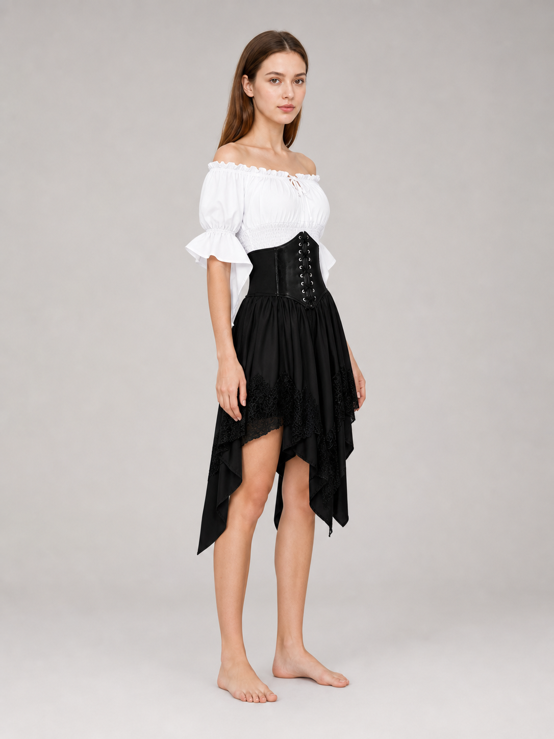 The set is designed in a theatrical pirate style and consists of a white cropped off-the-shoulder top with voluminous puff sleeves, a black corset with front lacing and metal eyelets, and a black asymmetrical skirt with elongated pointed pa
