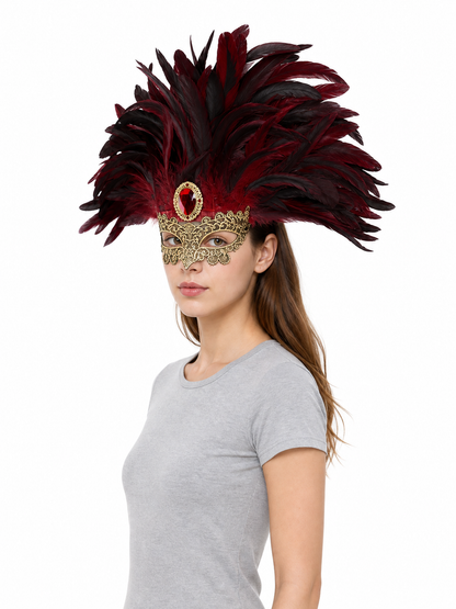 Side view of a model wearing a burgundy and black feathered mask headpiece with gold filigree and a red oval jewel