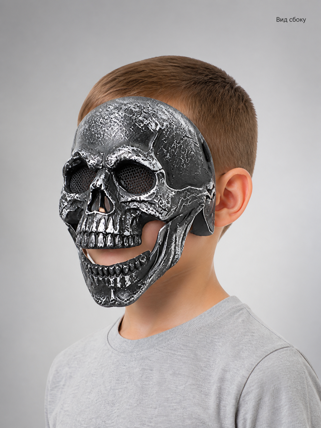 Black skull face mask with textured surface and raised teeth, shown in side profile on a model; Russian text identifies the side view