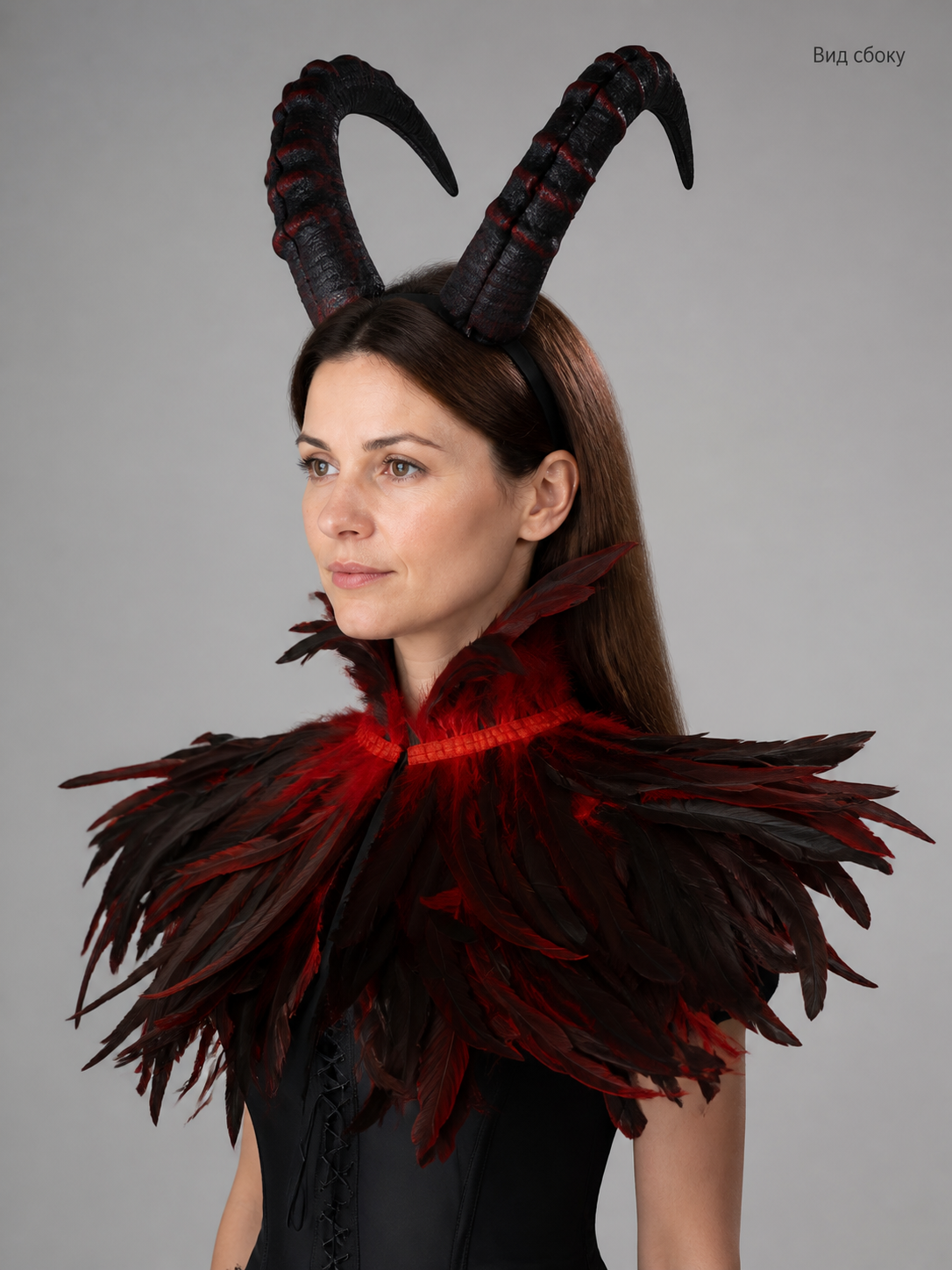 Information card showing a side view of the black and red horned headpiece and layered feather collar