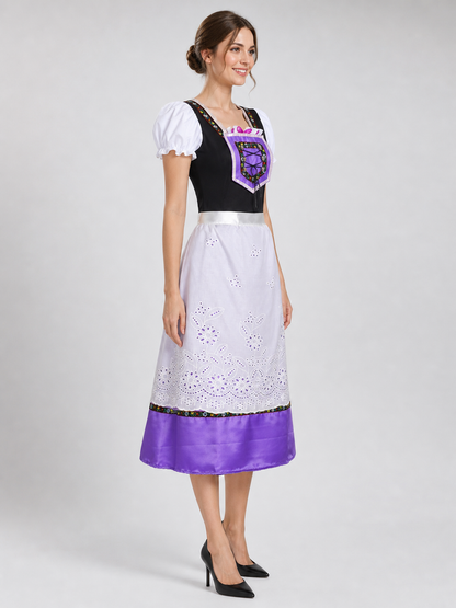 The dress is designed in an ethnic style and features a contrasting combination of white, pink, purple, and black. It has a black bodice, voluminous white puff sleeves, and a white waistband. The front is decorated with a purple lace-up det